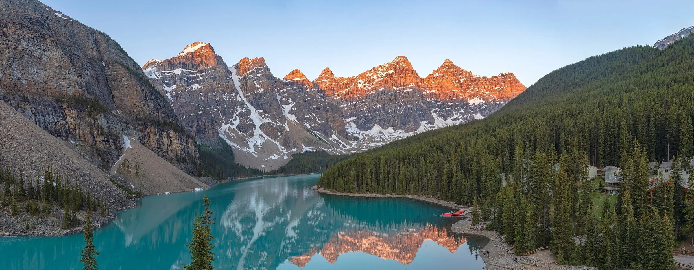 Le lac Moraine, turquoise, et les sommets rosés au lever du soleil, dans les Rocheuses canadiennes