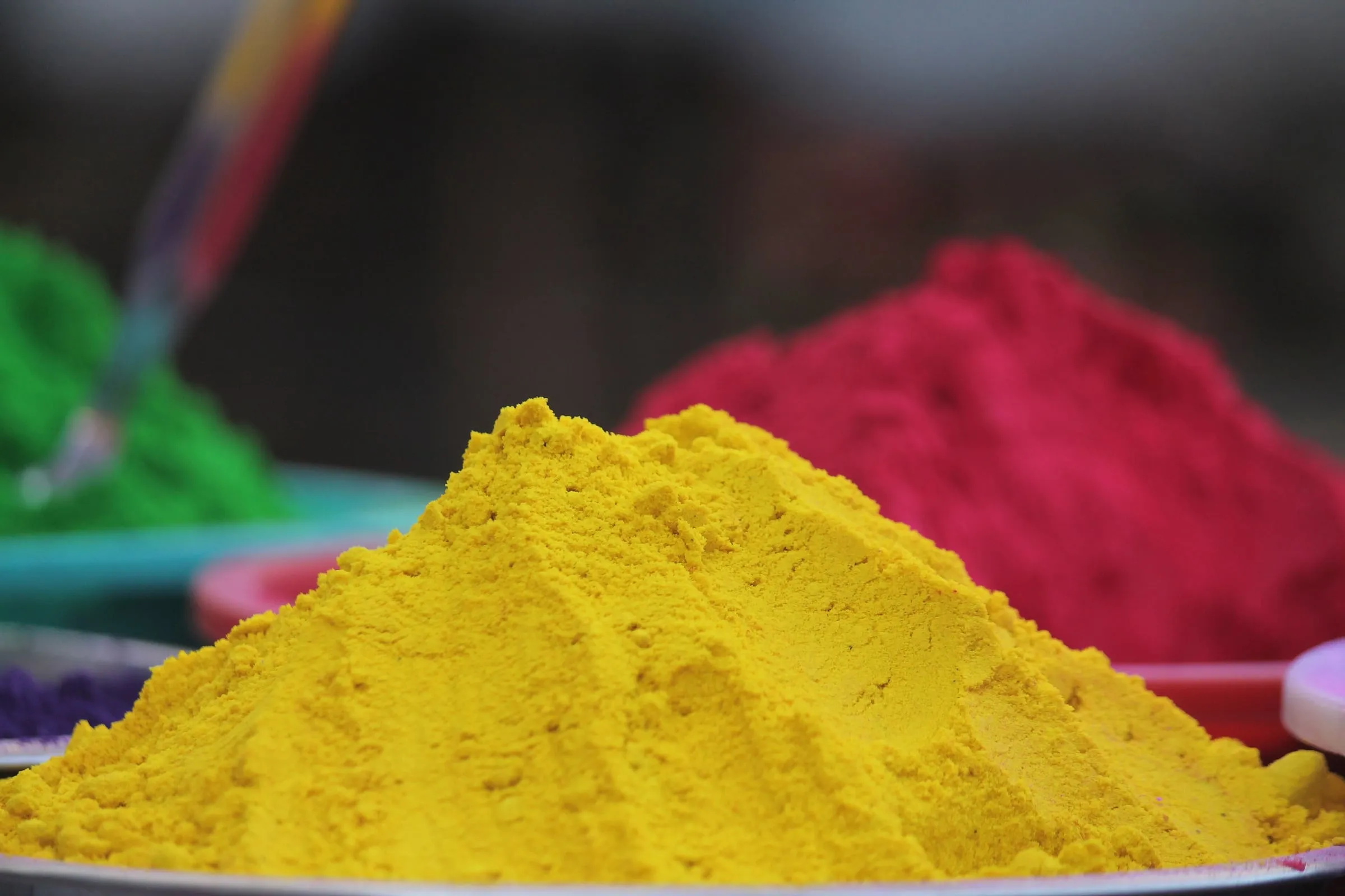 Tas de poudres colorées jaune, rouge et verte préparées pour Holi
