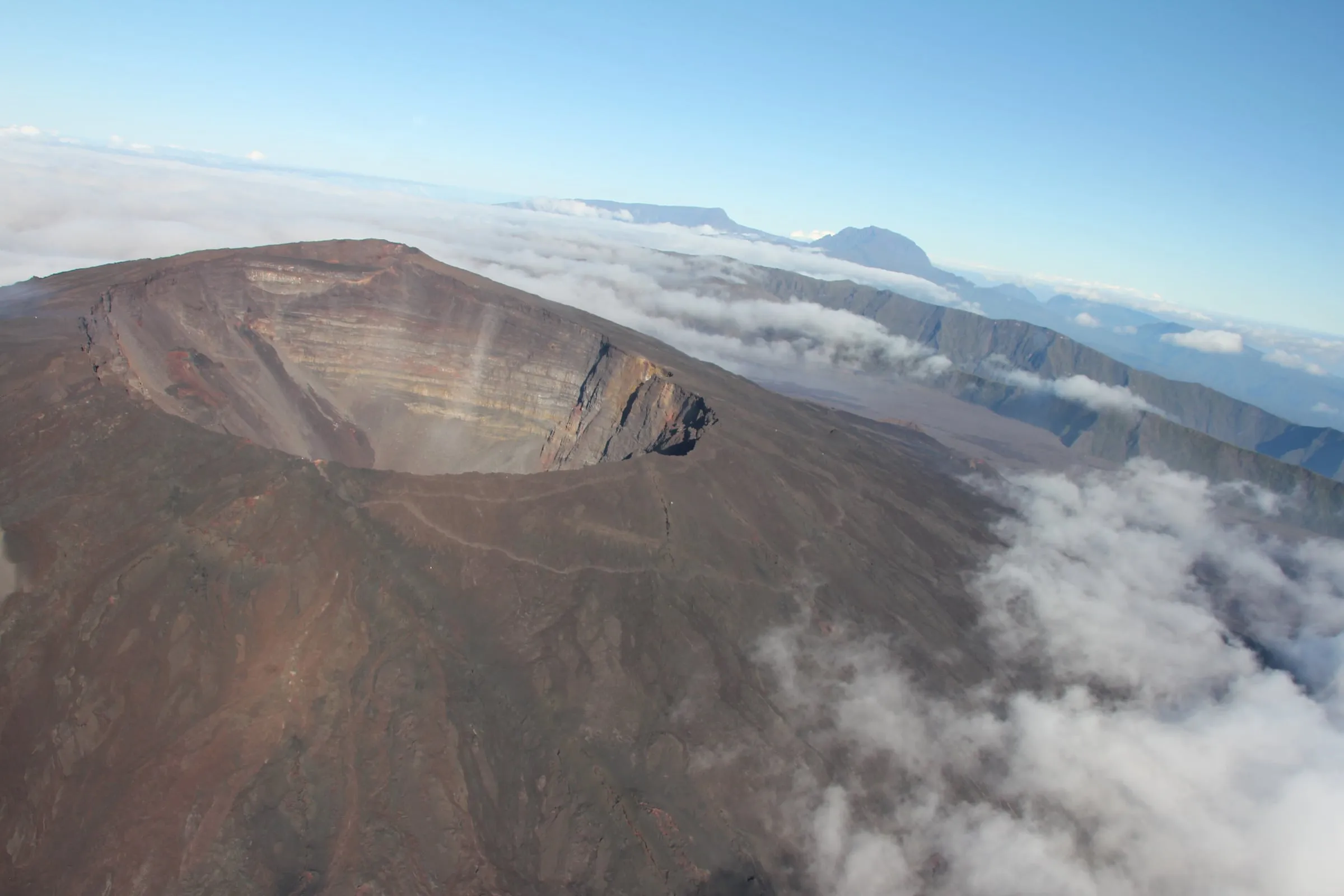 Le cratère Dolomieu du piton de la Fournaise vu du ciel, au-dessus d’une mer de nuages