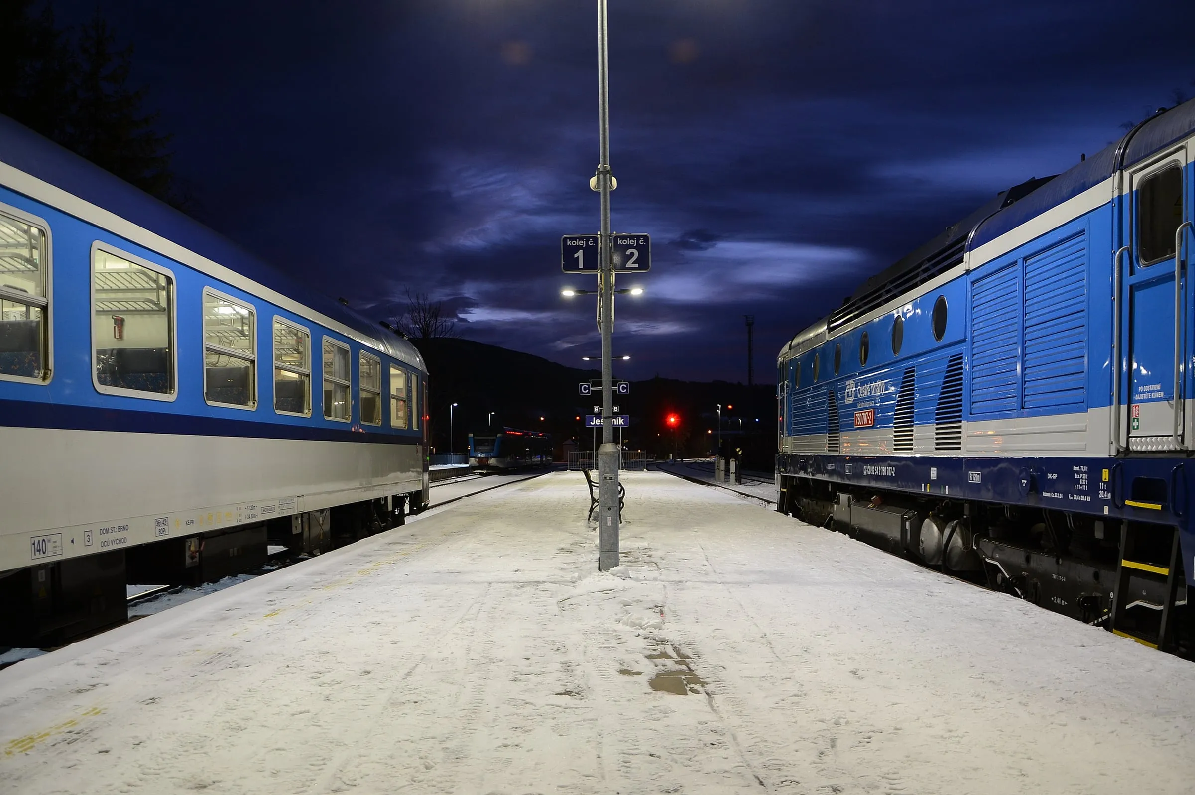 Quai enneigé la nuit entre deux trains, en gare de Jeseník (Tchéquie)
